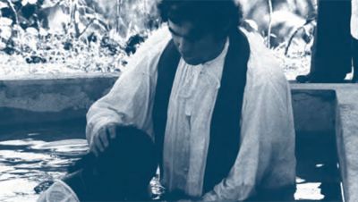 Fr. Frank Hoare baptizing by immersion, 1976